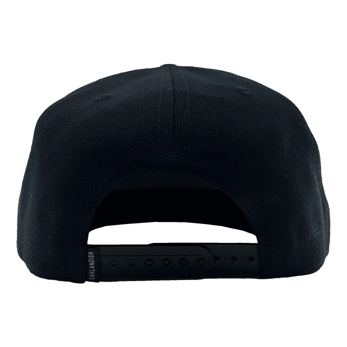 Back view of a black hat with black adjustable snapback closure with small Oakladish wordmark tag.