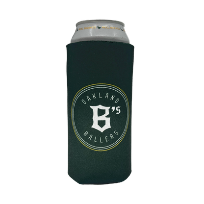A silver can is wrapped in an Oakland Ballers 24oz Can Cooler. The dark green cooler features the logo and text "OAKLAND BALLERS," celebrating Oakland's New Pro Baseball Team in the Pioneer League, with a prominent letter "B" and the number "6" combined in the center. The cooler is designed to keep beverages cool.