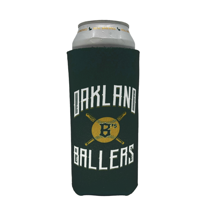 A beer can is wrapped in an Oakland Ballers 24oz Can Cooler. The dark green cooler features the text "Oakland Ballers" in white, with two crossed baseball bats and a golden baseball in the center. The baseball has the text "B's" in black, celebrating Oakland's new pro baseball team from the Pioneer League.
