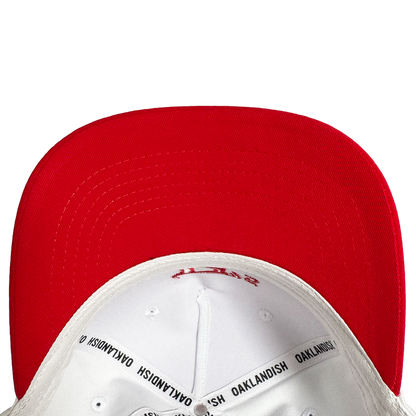 Close-up of the underside of the Oakland Ballers 5 Panel Cap, featuring a red brim and white crown. Black “OAKLANDISH” taping details the interior—a stylish nod to Oakland Ballers baseball. Plain white background.