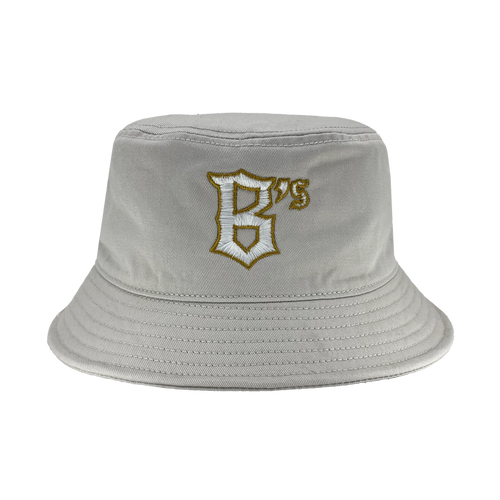 The Oakland Ballers B Bucket Hat is displayed in light grey with a wide, downward-sloping brim. The front showcases an embroidered design: a stylized letter "B" in white with a golden outline and the number "75" in gold, reflecting the legacy of the Oakland Ballers and their storied West Coast franchise history. The hat seems to be crafted from soft, flexible fabric.