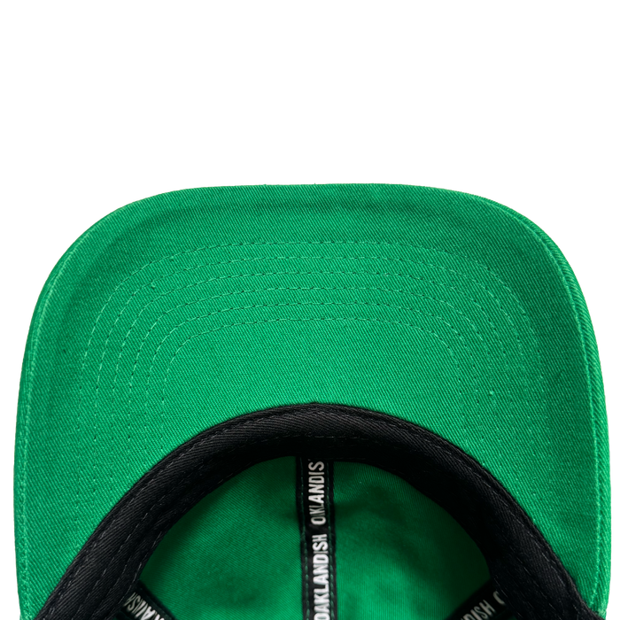 Close-up of the underside of the Oakland Ballers Dad Hat brim, highlighting detailed stitching. The black inner band displays white repeating text: "Oakland Ballers," echoing the brand's iconic style. Set against a plain white background.