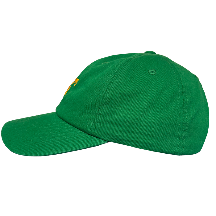 The Oakland Ballers Dad Hat features a green design with curved brim, structured panels, and visible stitching. An embroidered yellow accent nods to the Oakland Ballers, with a side eyelet for ventilation. Shown on a plain white background.