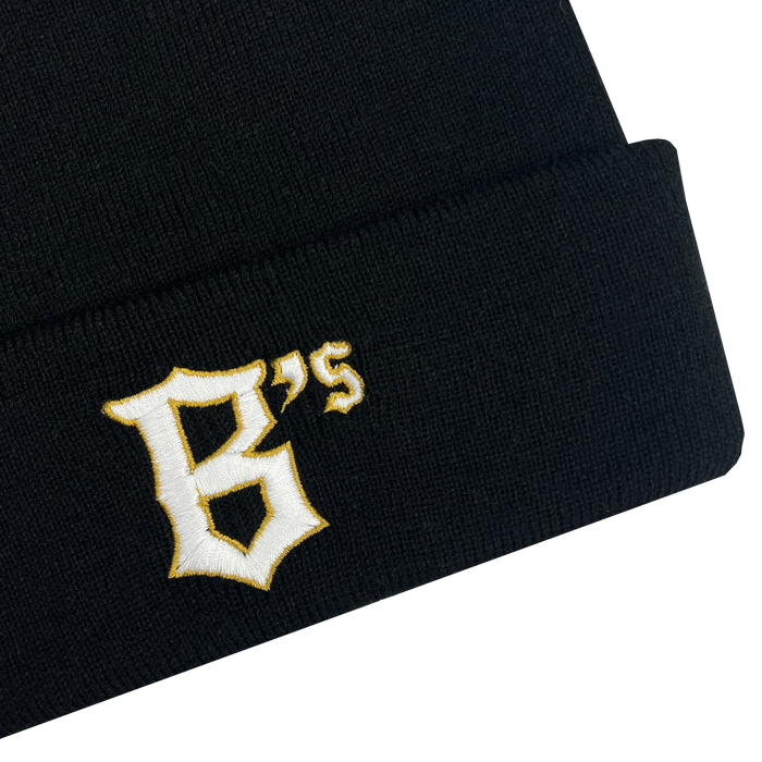 The Oakland Ballers Logo Beanie, a black knit beanie, features the embroidered letters "B's" in a stylized yellow and white font on the cuff, reminiscent of a professional baseball team logo. The plain white background highlights the beanie.