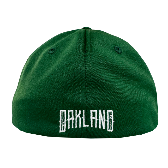 The Oakland Ballers Logo Flexfit Hat, by Oakland Ballers, is shown from the back in green with “OAKLAND” embroidered in bold white block letters. Two black ventilation eyelets are on top against a plain white background.
