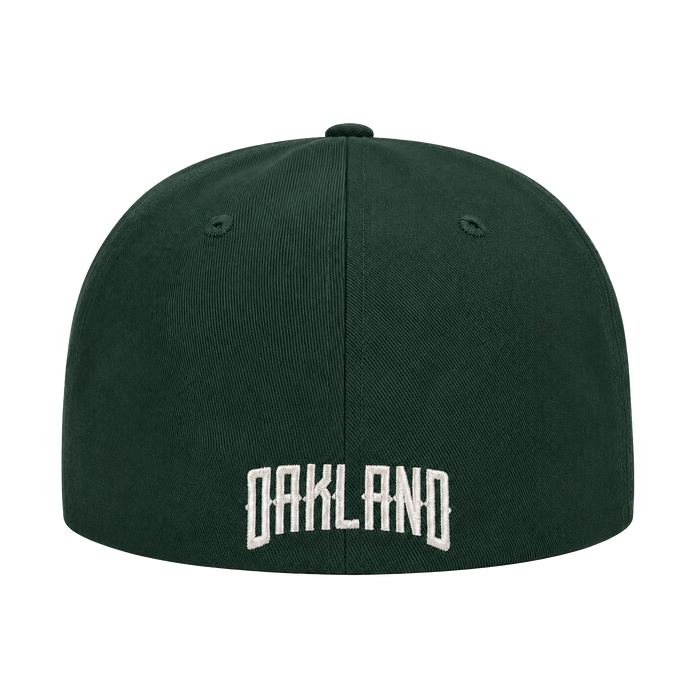 The Oakland Ballers Logo Hat by Oakland Ballers is a dark green baseball cap seen from the back, with "OAKLAND" embroidered in large white letters at the lower center and two ventilation holes per side. The background is plain white.