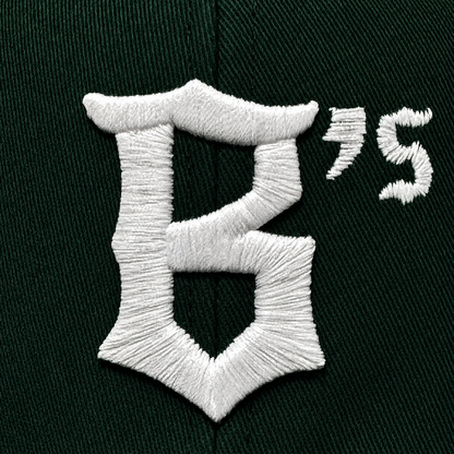 Close-up of the Oakland Ballers Logo Hat by Oakland Ballers, featuring dark green fabric with white embroidered "B’s" logo. Detailed stitching highlights this cap representing the new Oakland baseball team in the Pioneer League.
