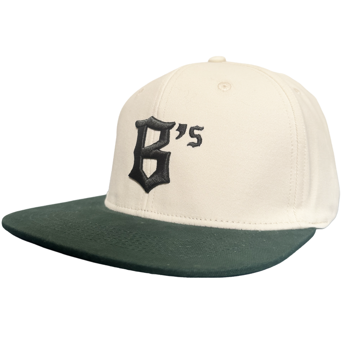 Introducing the Oakland Peloteros Hat by Oakland Ballers: This white cap features a dark green flat brim and showcases a prominent, black Gothic-style "B" with an adjoining apostrophe and "s" on the front—forming "B's," a proud symbol of the Oakland Ballers team from the Pioneer League. The background is crisp, clean white for a classic appeal.