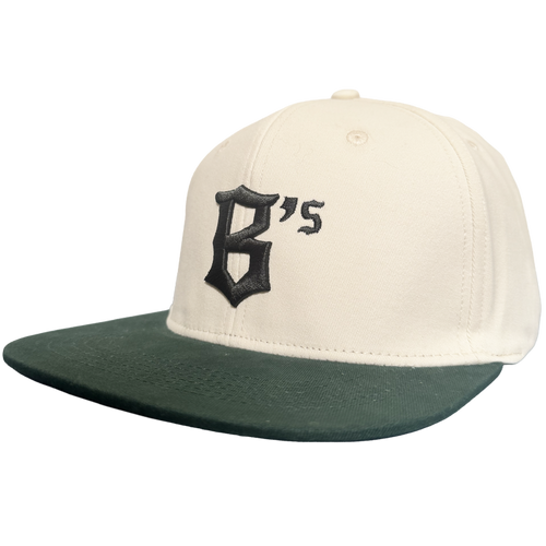 Introducing the Oakland Peloteros Hat by Oakland Ballers: This white cap features a dark green flat brim and showcases a prominent, black Gothic-style "B" with an adjoining apostrophe and "s" on the front—forming "B's," a proud symbol of the Oakland Ballers team from the Pioneer League. The background is crisp, clean white for a classic appeal.