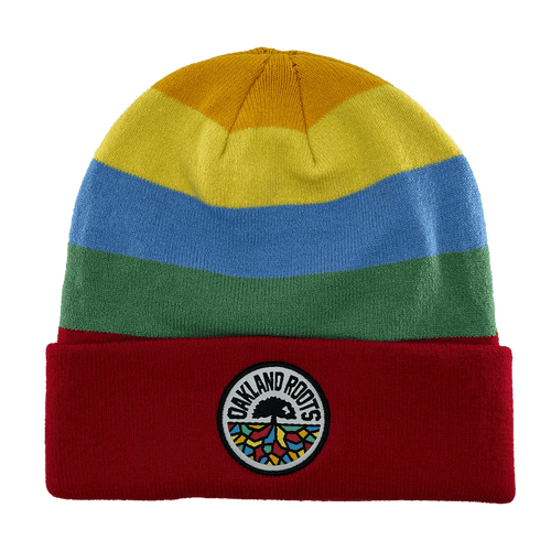 The Oakland Roots SC Mosaic Stripe Beanie features horizontal stripes in yellow, blue, and green, along with a red fold-over cuff. The cuff proudly displays a circular patch with the text "OAKLAND ROOTS," a black tree logo, and rainbow-colored roots to show your support for the Oakland Roots Sports Club.