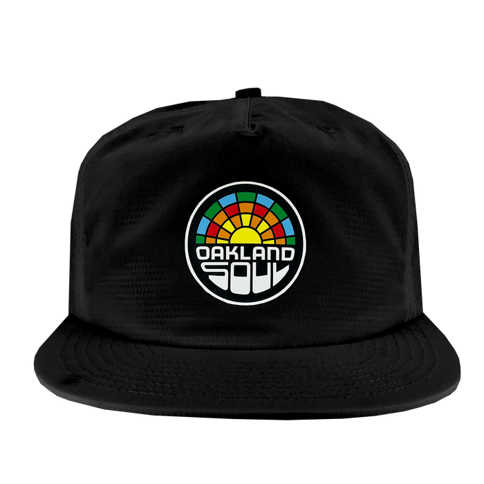 The Oakland Soul Surf Cap is a black snapback hat featuring a colorful embroidered logo in the center. The circular logo showcases a multi-colored segmented pattern of red, orange, yellow, green, and blue, with the text "OAKLAND SOUL" in bold, white stylized letters beneath it, celebrating the USL W-League's vibrant women's soccer team.