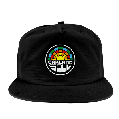 The Oakland Soul Surf Cap is a black snapback hat featuring a colorful embroidered logo in the center. The circular logo showcases a multi-colored segmented pattern of red, orange, yellow, green, and blue, with the text "OAKLAND SOUL" in bold, white stylized letters beneath it, celebrating the USL W-League's vibrant women's soccer team.