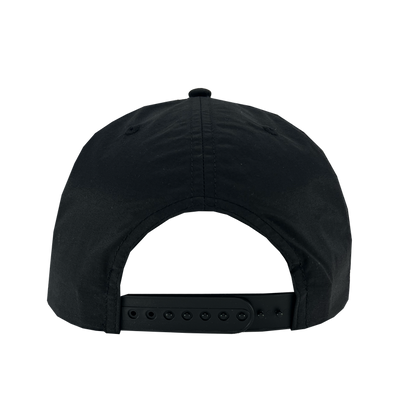 The image displays the back view of the Oakland Soul Surf Cap, a black baseball cap ideal for fans of the USL W-League's Oakland Soul women's soccer team. This cap, from the Oakland Soul brand, features a classic snapback closure with small holes and a plastic strap for adjustable fitting. The top part of the cap is adorned with visible stitching and a small fabric button.