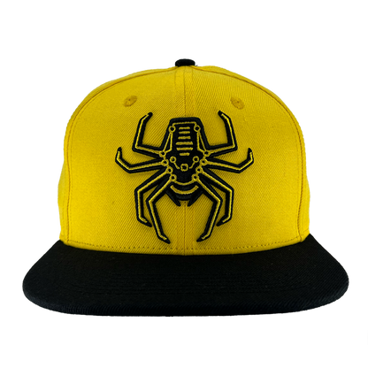 Front view of yellow snapback hat with Oakland Spiders logo on crown and black brim.
