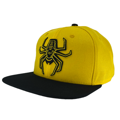 Angled view of yellow snapback hat with Oakland Spiders logo on crown and black brim.