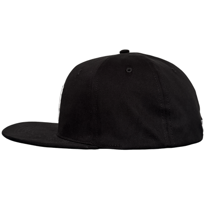 The Oakland Stand Up Hat by Oakland Ballers is a black, flat-brim baseball cap with a structured crown and small top button, shown from the left side on a plain light gray background. The cap has no visible logos or designs.