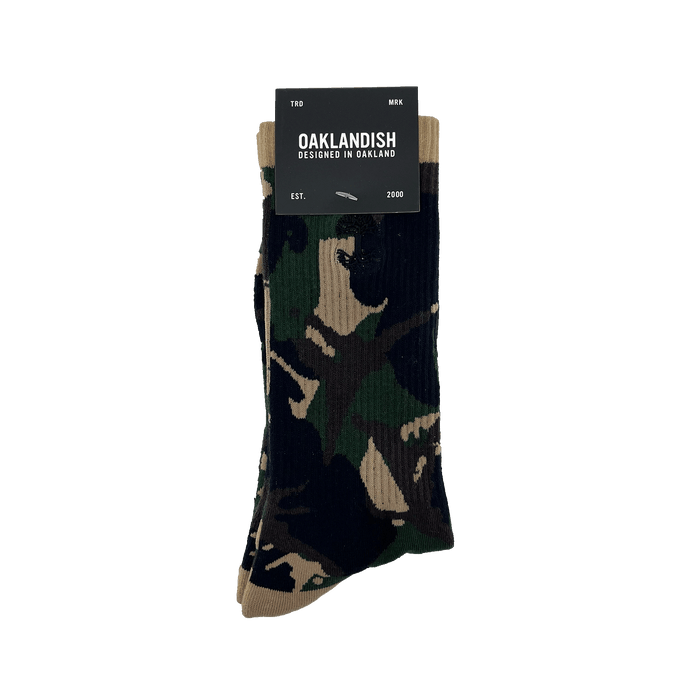 Pair folded camo crew socks in Oaklandish packaging with an embroidered black Oaklandish tree logo on the side.