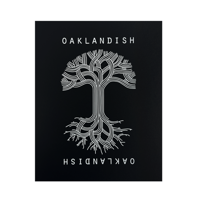 A symmetrical tree with branched lines forming roots and branches is centered against a black background in the Oaklandish Classic Logo Print by Never Elsewhere. The white text "OAKLANDISH" appears above and below the tree, with the lower text inverted. The design has a modern, graphical look reminiscent of a letterpress print, creating a striking contrast.