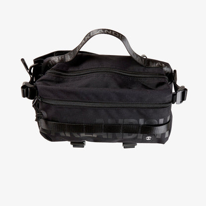 A black nylon hip bag with a black Oaklandish wordmark top zipper, front zipper, top handle, waist belt, & small white Oaklandish tree logo.