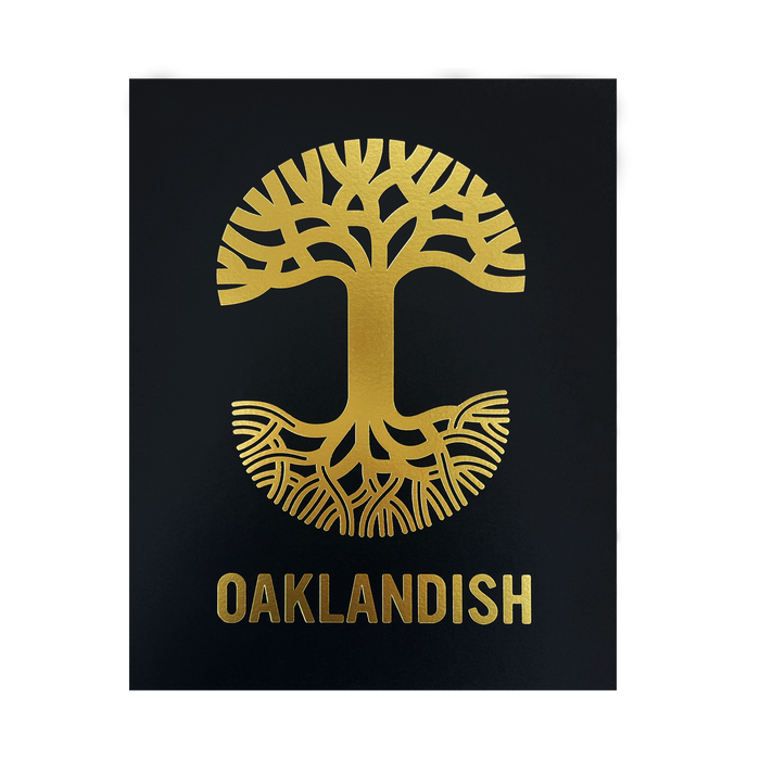 The Oaklandish New Logo Print by Never Elsewhere showcases a gold emblem of a stylized tree with branches extending upwards and roots spreading downwards against a black background. Below the tree, the word "OAKLANDISH" is also rendered in gold, complementing the emblem. The design has a symmetrical and minimalist aesthetic reminiscent of a letterpress print.