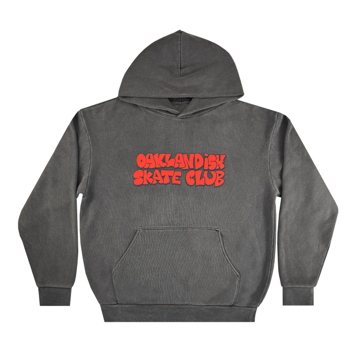 The Oaklandish Skate Club Hoodie by Oaklandish is a charcoal-grey pullover with a front pocket and hood. "OAKLANDISH SKATE CLUB" in bold, wavy red letters decorates the chest. The hoodie is shown laid flat on a white background.
