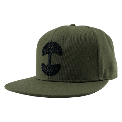 The Old English Aft Snapback is an olive green hat with a flat brim, showcasing an intricate black Oaklandish tree logo embroidered on the front center. This cap features a structured crown, adjustable snapback closure, and appears new and unworn, all set against a transparent background.