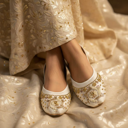 White embroidered shoes on a matching fabric background