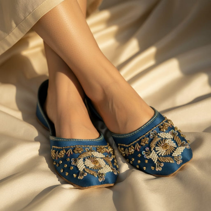 Blue embroidered shoes on a beige fabric background
