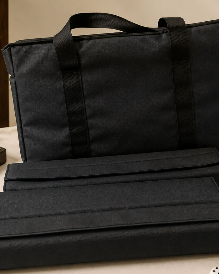 Black mahjong carry bag with two folded tile rack case sleeves inside, handles