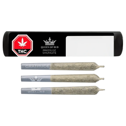 Top-down view of three ash-coated pre-rolls alongside a black rectangular tube labeled "Princess Cut Shungite Infused PR 3 x 0.5 g" with a red THC stop sign and Queen of Bud logo.