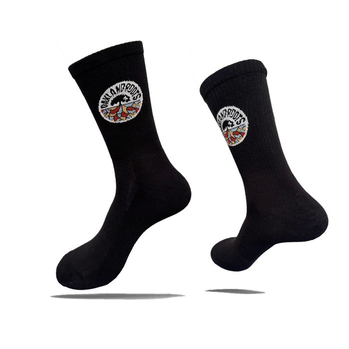 Two black cotton crew Roots SC Socks by Oakland Roots SC are shown against a white background. Each adult-sized sock features a round “NOMAD NOMADS” patch with colorful wings near the top and appears to float with shadows below.