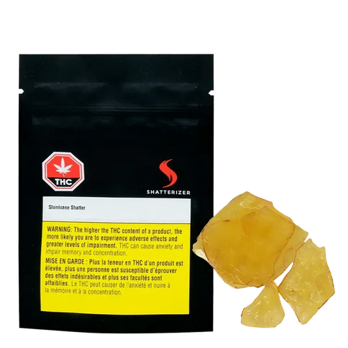 Close-up of golden-amber Slurricane Shatter, displayed against a black background with warning text and branding.