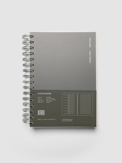 Spiral Notebook | A5 | Weekly Checklist shown closed on a neutral background, dark olive cover with a printed layout key and silver spiral binding