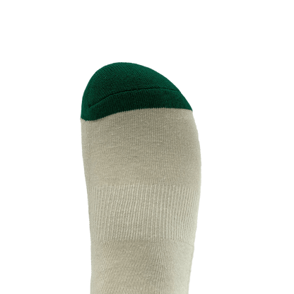 Image showing a close-up of a single foot wearing the Oaklandish Striped Classic Sock. The sock, available in adult sizes, is primarily light gray in color with a dark green toe section. Made with 70% cotton, the background is plain white, emphasizing the sock and its contrasting colors.