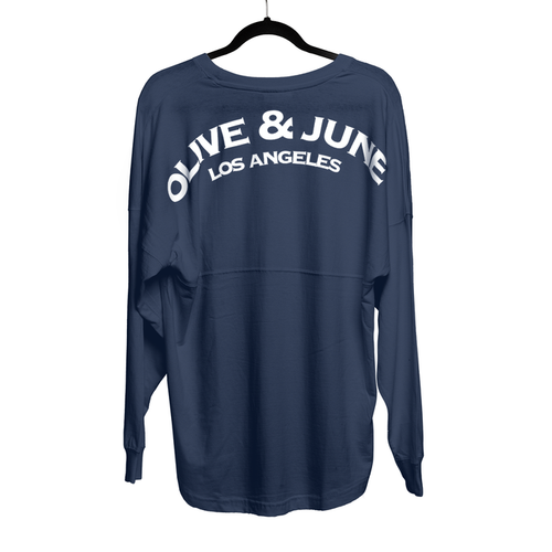 Navy oversized Summer Sailor Long Sleeve Shirt with white Olive & June Los Angeles lettering on back hanging on black hanger