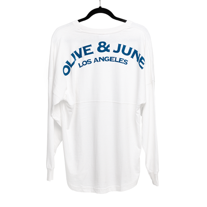 White oversized Summer Sailor Long Sleeve Shirt with blue Olive and June Los Angeles lettering on back on black hanger