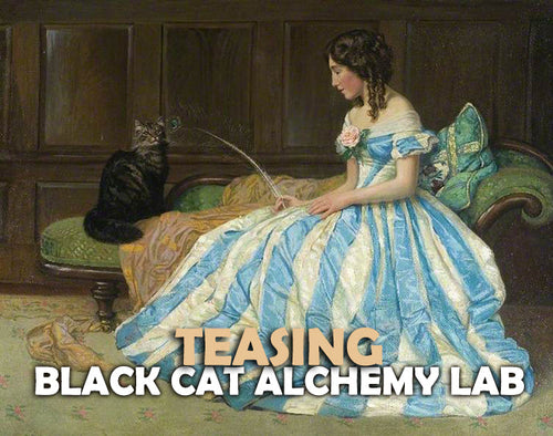 Woman in a blue and white dress sitting on a couch with a black cat, text overlay 'Teasing Black Cat Alchemy Lab'.