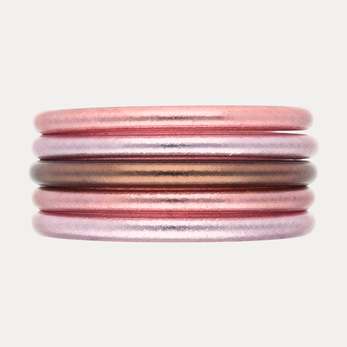 The Pink Tidal Stack features five exquisite bangles in pearlescent coastal pinks and radiant finishes.