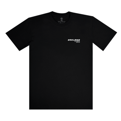 The Tuner Tee by Oaklandish is a black, classic-fit short-sleeved shirt made of 100% cotton. It features a small white "OAKLAND" logo on the upper left chest in bold uppercase letters, offering a minimalist and modern look. Available in men's sizes, it's displayed on a white background.