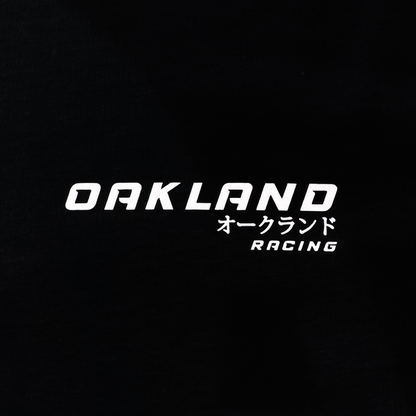 The Tuner Tee by Oaklandish is a classic fit men's 100% cotton t-shirt featuring "OAKLAND" in white text on a black background, with smaller Japanese characters and "RACING" stylishly shown underneath.