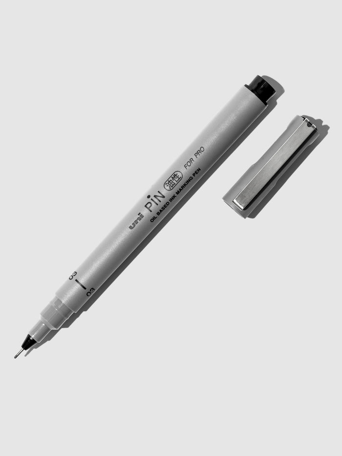 Uni Pin Marking Pen, 03, Cloth and Paper. Pen against a neutral background.