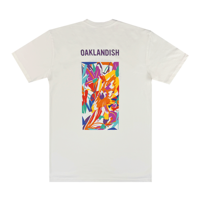 The Urban Tropics Tee by Oaklandish features bold purple "OAKLANDISH" text on the upper back and a vibrant floral design by Oakland artist Kalani Ware in a central rectangular panel.