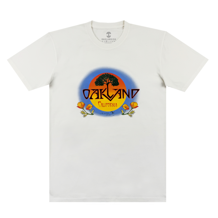 The Oaklandish Vanguard Tee is a white classic fit with an oak tree and sunset graphic. “OAKLAND” in bold yellow sits above “California,” with two orange poppies at the base. Inspired by Stanley Mouse.