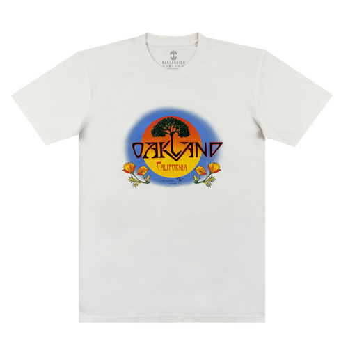 The Oaklandish Vanguard Tee is a white classic fit with an oak tree and sunset graphic. “OAKLAND” in bold yellow sits above “California,” with two orange poppies at the base. Inspired by Stanley Mouse.