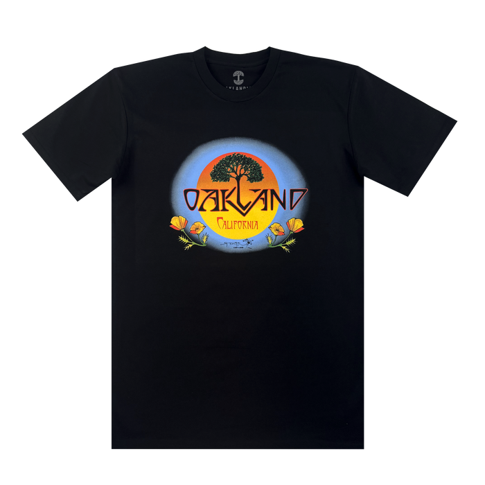 The Oaklandish Vanguard Tee features a classic fit and a Stanley Mouse-inspired graphic: a large tree silhouetted against an orange and blue sunset, with “OAKLAND” above “California” on a yellow banner, plus orange poppies and green leaves.