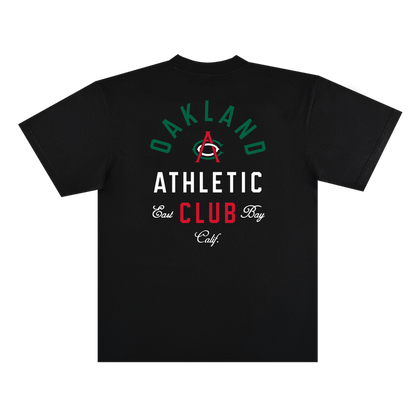 The Viva OAC Tee by OAC is a black, classic fit t-shirt crafted from heavy-weight cotton. The back showcases “OAKLAND ATHLETIC CLUB” and “East Bay Calif.” in green, white, and red fonts, highlighted by a large red “A” with a green arc centered among the text.