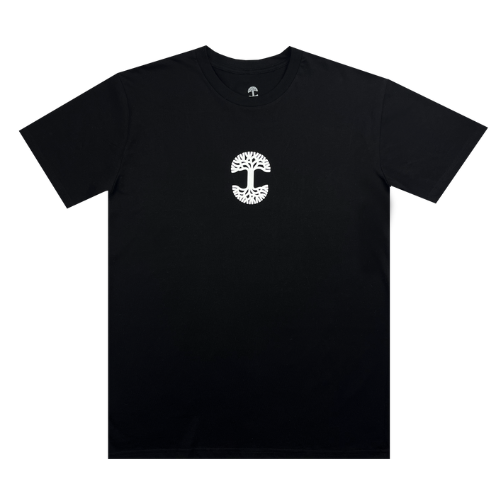 The "Who We Are and Who We Do it For Tee" by Oaklandish is a plain black, 100% cotton T-shirt featuring a small white logo on the chest. The logo resembles a stylized tree with a wide canopy and complex root system, enclosed within an oval shape. This classic fit T-shirt has short sleeves and a round neck, perfect for showcasing your Oakland pride.