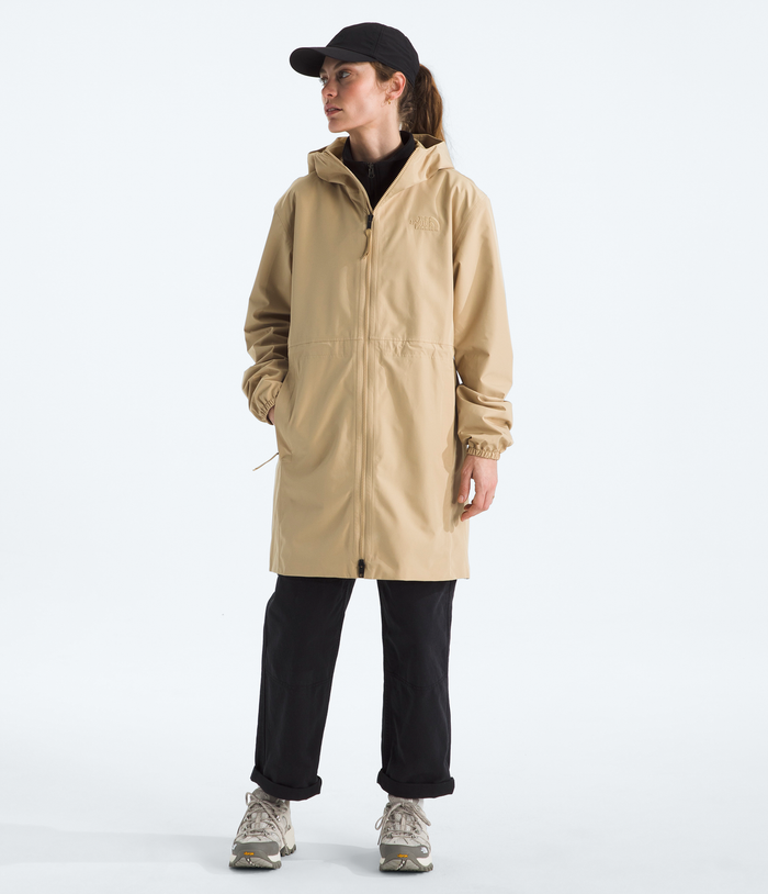 Person wearing a beige raincoat on a white background