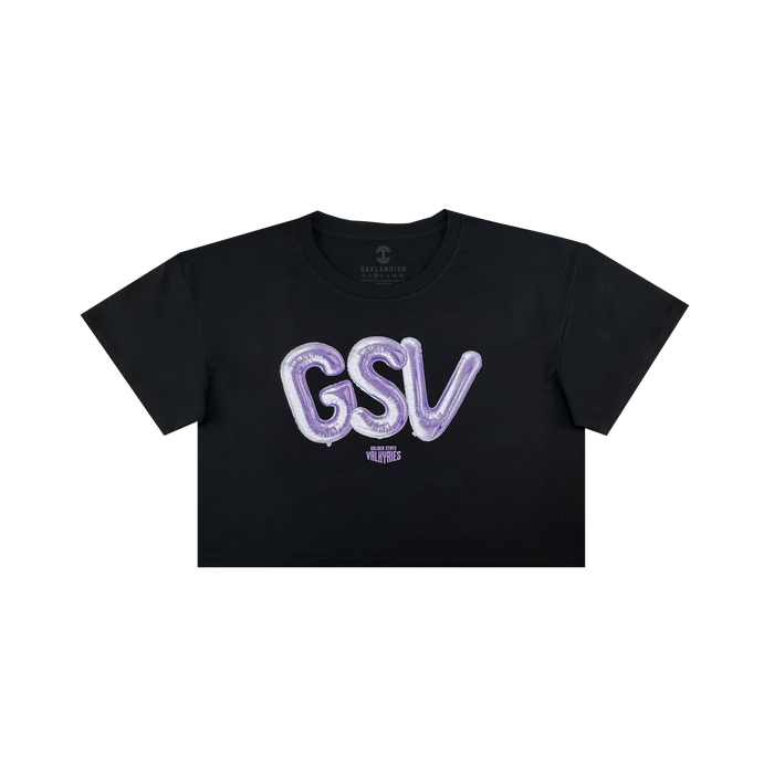 The Women’s Golden State Valkyries Balloons Crop Tee by GSV is a black cropped t-shirt with bold, shiny purple “GSV” balloon letters and a small white “VLVT STUDIOS” logo beneath, inspired by the Golden State Valkyries.