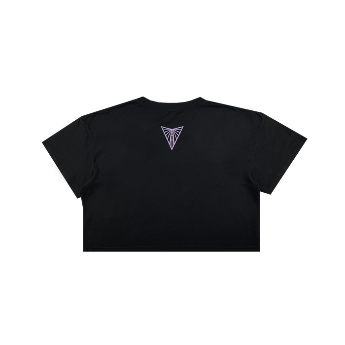 The Women's Golden State Valkyries Balloons Crop Tee by GSV is shown from the back in black, featuring a small purple geometric emblem near the neckline on a plain background. No other designs or text are visible; background is white.